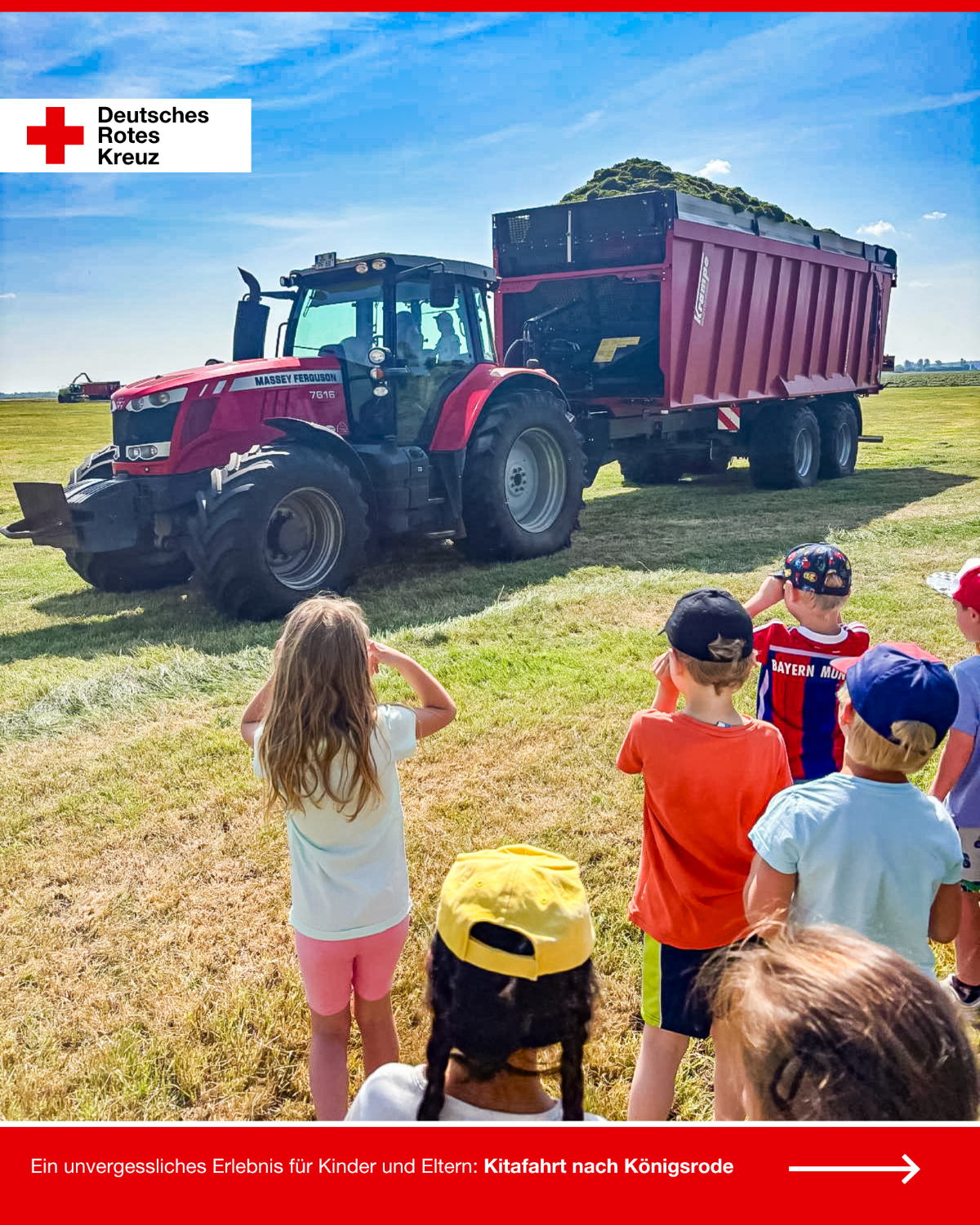 Kinder der DRK-Kita „Rasselbande“ stehen auf einer Wiese und beobachten einen Traktor mit voll beladenem Anhänger während der Kitafahrt in Königsrode.