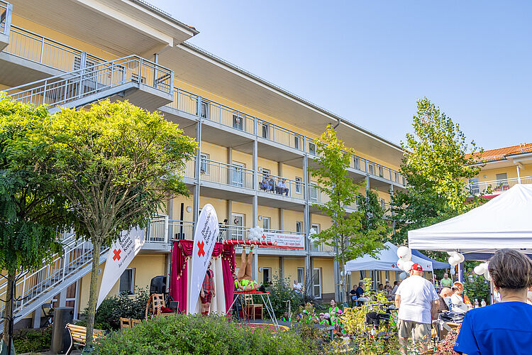 Feier zum 10-jährigen Bestehen des DRK-Seniorenwohnparks Magdeburg am 9. Mai 2024 mit Bühne, Pavillons und Gästen im Innenhof der Wohnanlage.