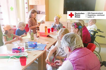 Ein Mädchen hilft einer Seniorin beim Basteln im DRK-Seniorenzentrum Genthin.