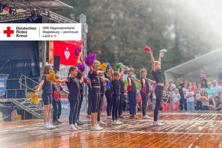 Kinder der Cheerleading-AG des DRK-Hortes „Diesterweg“ treten beim Kartoffelfest auf und heben ihre bunten Pompons in die Höhe.