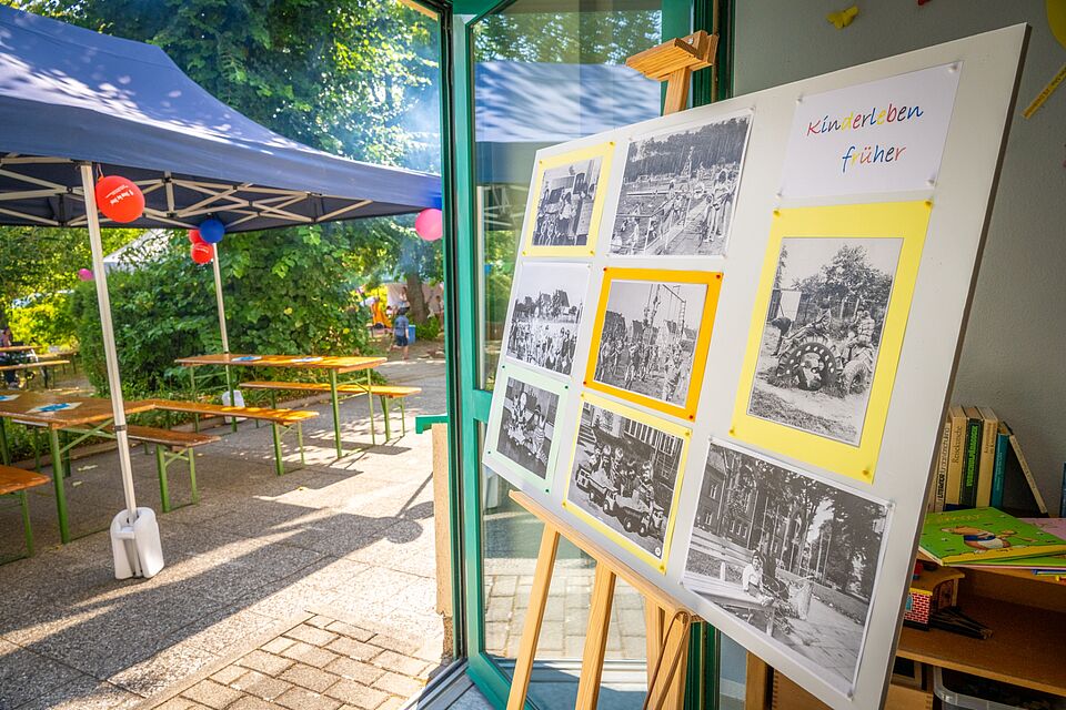 Stellwand mit historischen Schwarz-Weiß-Fotos über Kinderleben früher.