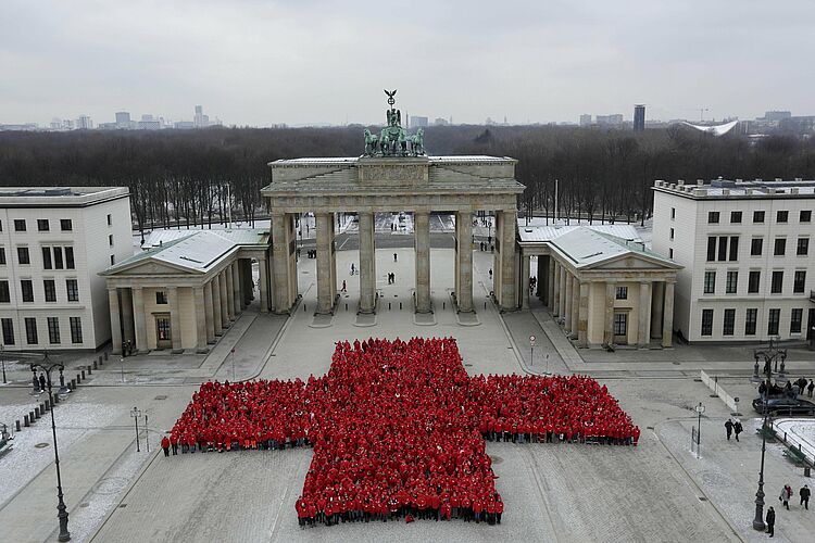 Mehrere tausend DRK-Helferinnen und Helfer bilden am 13. Januar 2013 vor dem Brandenburger Tor in Berlin ein riesiges Rotes Kreuz zum Jubiläum 150 Jahre Deutsches Rotes Kreuz.