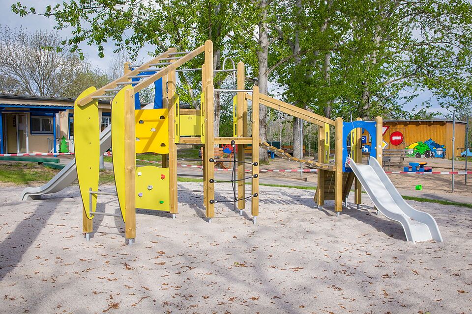 Buntes Klettergerüst mit Rutsche und Kletterwand auf dem Spielplatz der DRK-Kita „Bambi“