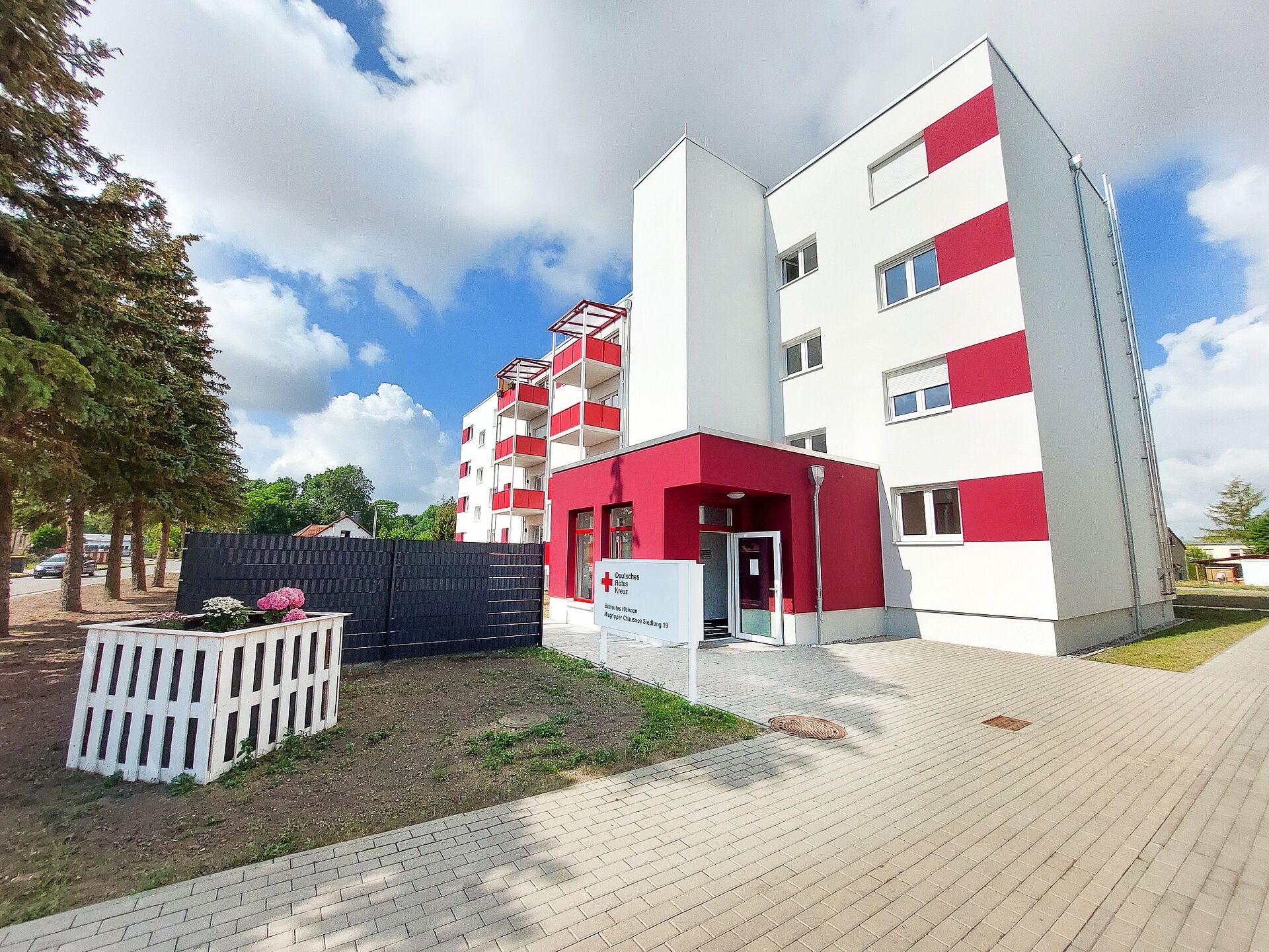 Außenansicht des Betreuten Wohnens „Niegripper Chaussee“ (Siedlung) des DRK in Burg. Sofern eine Person vor dem Gebäude im Mittelpunkt steht, sollte sie zusätzlich neutral beschrieben werden.
