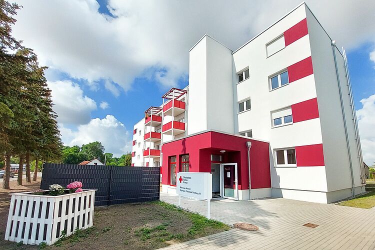 Außenansicht des Betreuten Wohnens „Niegripper Chaussee“ (Siedlung) des DRK in Burg. Sofern eine Person vor dem Gebäude im Mittelpunkt steht, sollte sie zusätzlich neutral beschrieben werden.