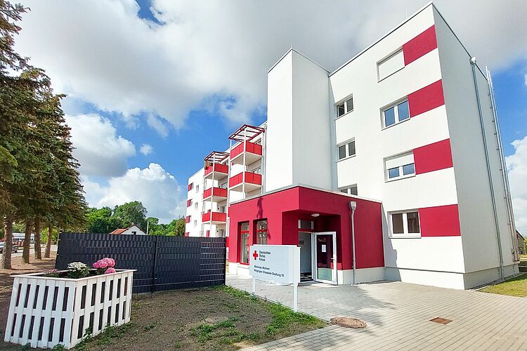 Außenansicht des Betreuten Wohnens „Niegripper Chaussee“ (Siedlung) des DRK in Burg. Sofern eine Person vor dem Gebäude im Mittelpunkt steht, sollte sie zusätzlich neutral beschrieben werden.