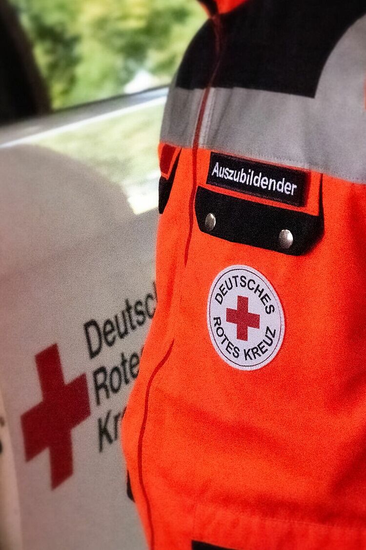 Detailaufnahme der DRK-Dienstkleidung der neuen Notfallsanitäter-Auszubildenden mit Aufschrift „Auszubildender“.
