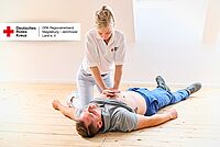 DRK-Ausbilderin übt Wiederbelebung an einem Teilnehmer während eines Erste-Hilfe-Kurses.