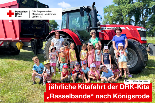 Kinder der DRK-Kita „Rasselbande“ und drei Erzieherinnen stehen und knien lachend vor einem großen roten Traktor auf einer Wiese in Königsrode.