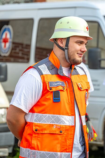 DRK-Helfer mit Helm und orangefarbener Einsatzweste beim Dienstabend.