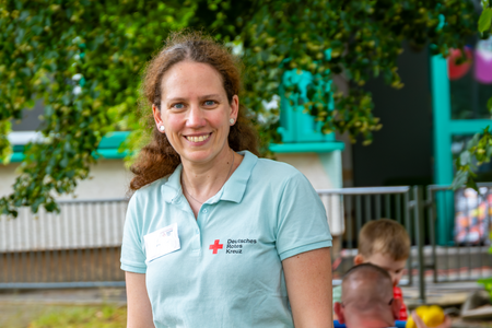 Stephanie Martius, Leitung der DRK-Kita „Rasselbande“ Frau Stephanie Martius, Einrichtungsleiterin, steht lächelnd beim Jubiläumsrundgang im Kita-Garten.