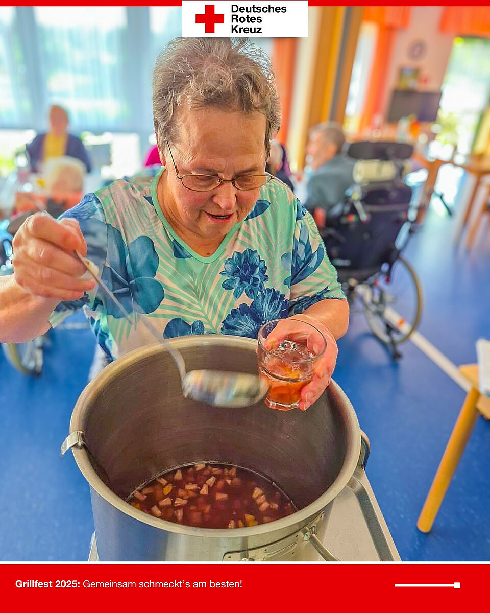 Bewohnerin füllt beim Grillfest 2025 im DRK-Seniorenzentrum Möckern eine Bowle mit Früchten in ein Glas.