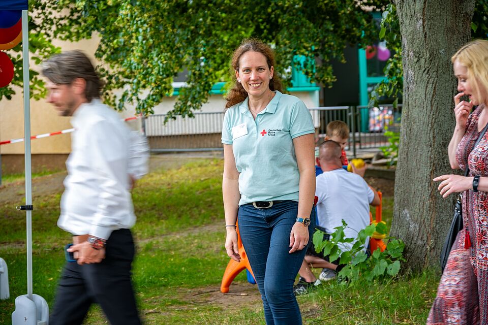 Frau Stephanie Martihus, Einrichtungsleiterin, steht lächelnd beim Jubiläumsrundgang im Kita-Garten.