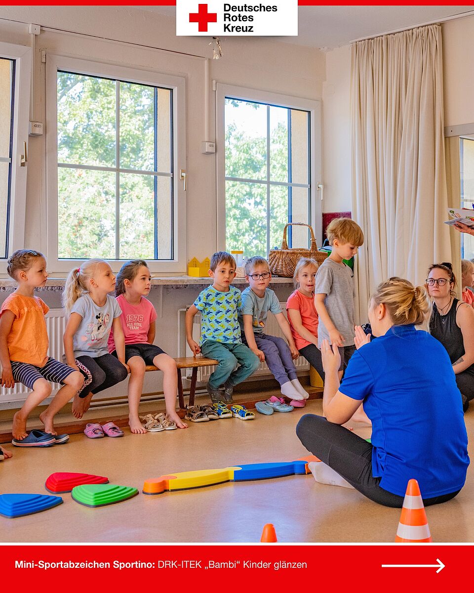 Kinder der DRK-ITEK „Bambi“ sitzen gespannt und hören den Anweisungen beim Mini-Sportabzeichen Sportino zu.