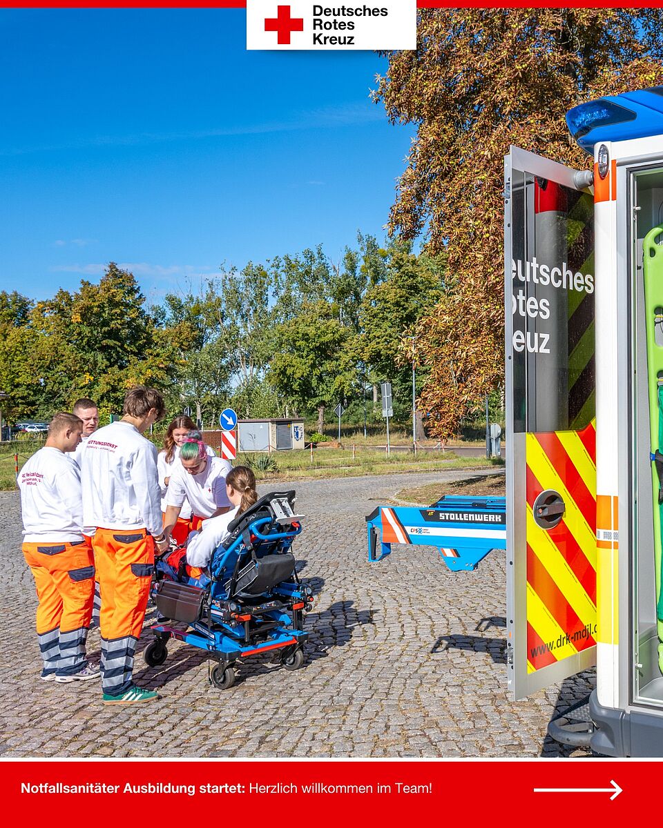 Neue Notfallsanitäter-Azubis üben den Umgang mit der Trage am Rettungswagen.